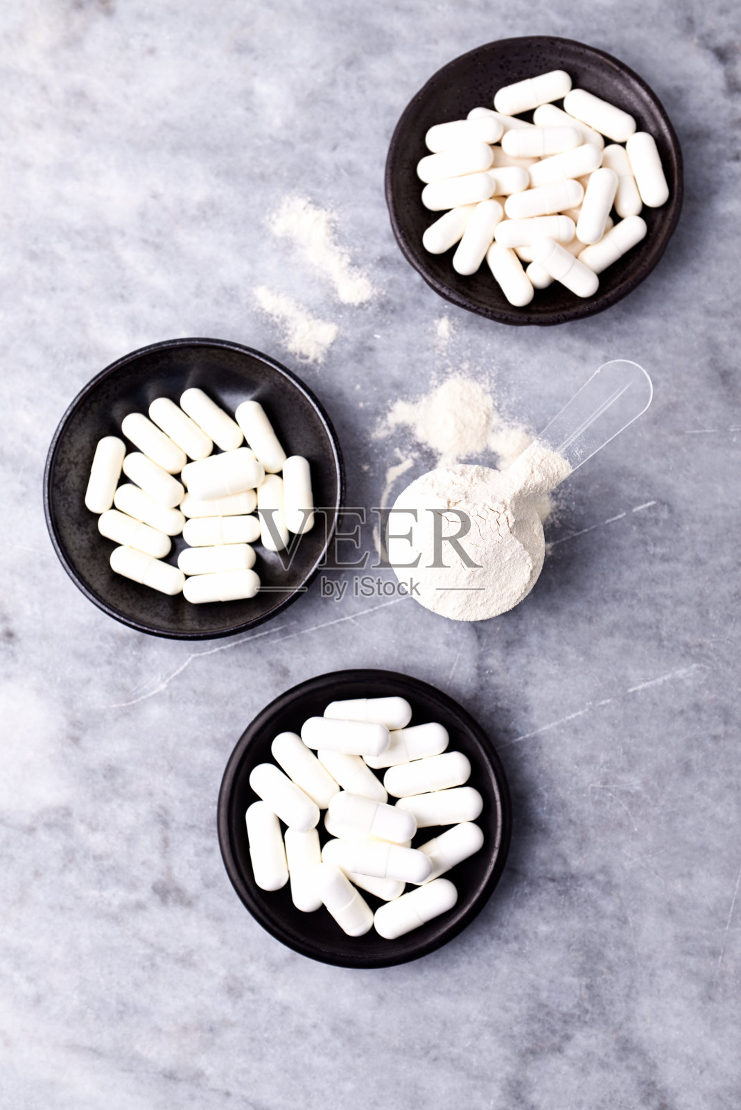 乳清蛋白,水解膠原I型,l -脯氨酸和l -賴氨酸膠囊勺。補(bǔ)充膠原蛋白的生產(chǎn)。明亮的石頭背景。直接上圖。副本的空間。